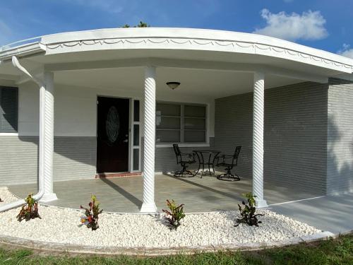 un pabellón con 2 sillas y una mesa en un patio en Cozy 3-bed home close to beautiful beaches. en New Port Richey