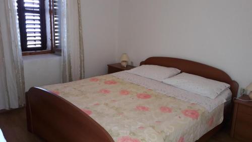ein Schlafzimmer mit einem Bett mit einer Blumendecke in der Unterkunft Apartments with a parking space Savar, Dugi otok - 12762 in Brbinj