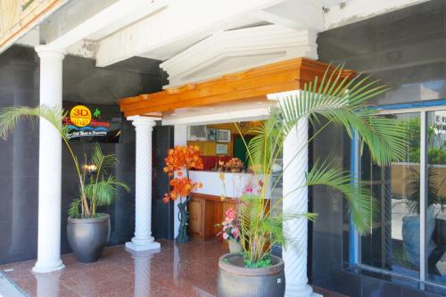 a store front with three potted plants in pots at 3Ds International Tourist Home in Mahébourg