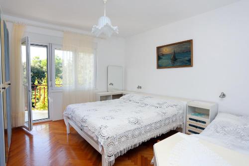 ein weißes Schlafzimmer mit 2 Betten und einem Fenster in der Unterkunft Apartments with a parking space Seget Vranjica, Trogir - 12760 in Donji Seget