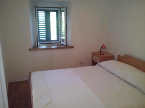 - une chambre avec un lit blanc et une fenêtre dans l'établissement Apartment Sumartin 11658b, à Sumartin