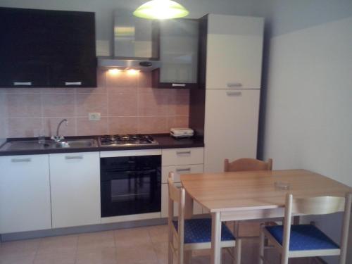 a kitchen with a wooden table and a table and chairs at Apartment Sumartin 11658b in Sumartin