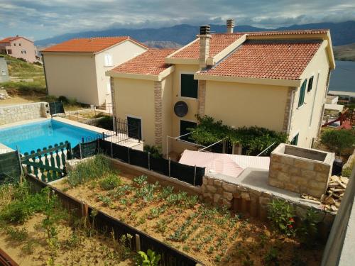 a villa with a swimming pool in front of a house at Apartment Pag 12795a in Pag