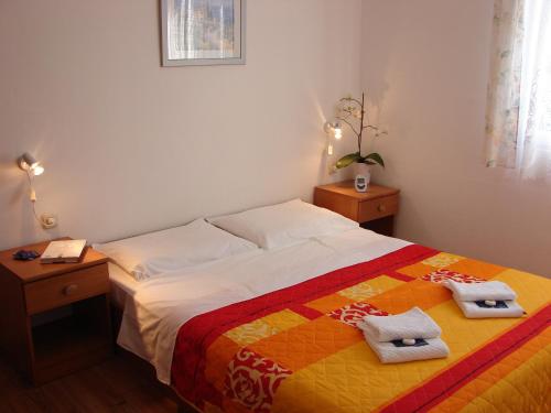 ein Schlafzimmer mit einem Bett mit zwei Handtüchern darauf in der Unterkunft Family friendly apartments with a swimming pool Pag - 12795 in Pag