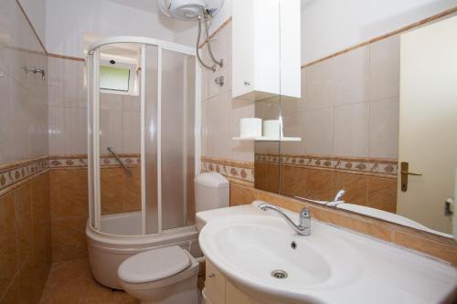 a bathroom with a sink and a toilet and a shower at Apartments with parking space Podgora, Makarska - 12816 in Podgora