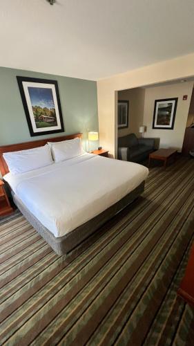 a bedroom with a large white bed and a living room at White Pine Lodge in Salamanca