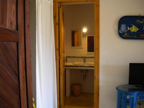 - une porte ouverte donnant sur une salle de bains avec lavabo dans l'établissement Casa U' Cucunciu, à Lipari