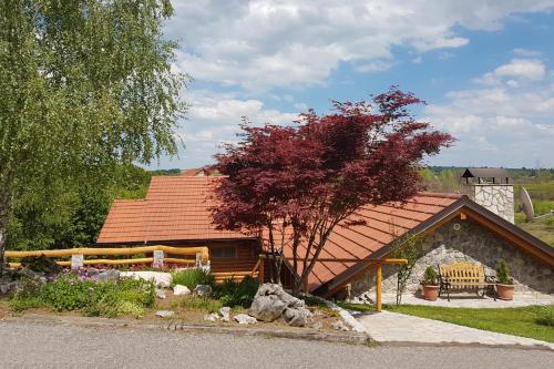 ein Haus mit einem roten Dach und einem Baum in der Unterkunft Rooms with a parking space Grabovac, Plitvice - 12835 in Rakovica