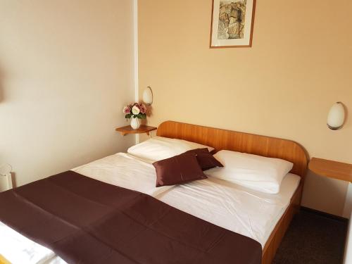 Schlafzimmer mit einem Bett mit weißer Bettwäsche und einem Kopfteil aus Holz in der Unterkunft Rooms with a parking space Grabovac, Plitvice - 12835 in Rakovica