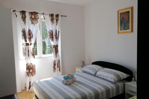 a bedroom with a bed with two stuffed animals on it at Apartments with a parking space Mocici, Dubrovnik - 12856 in Čilipi