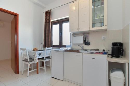 a kitchen with white cabinets and a table and chairs at Apartments with WiFi Fazana - 12862 in Marana