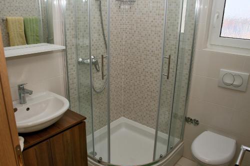 La salle de bains est pourvue d'une douche et d'un lavabo. dans l'établissement Apartments with a parking space Bilo, Primosten - 12870, à Primošten