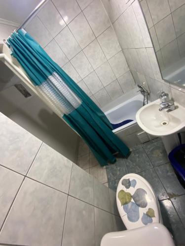 a bathroom with a green umbrella next to a sink at Habitaciones en pensión en centro de Iquique in Iquique