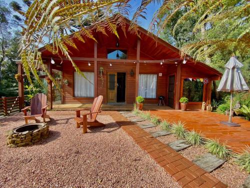 a log cabin with a porch and a patio at CHALÉ MONTANHÊS ALPES in São Francisco de Paula