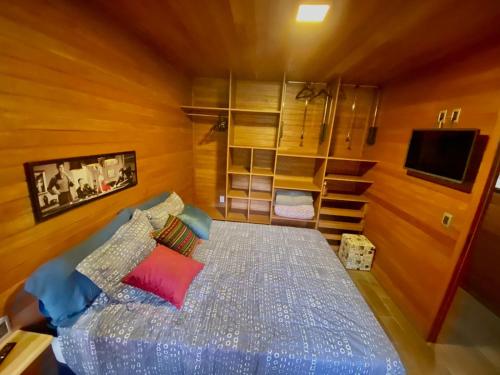 a bedroom with a bed and a tv in it at CHALÉ MONTANHÊS ALPES in São Francisco de Paula