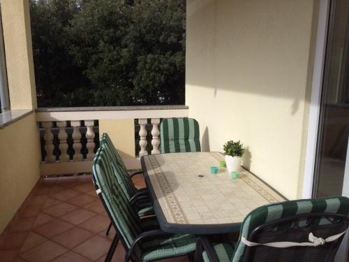 a table and chairs on a balcony with a table and a window at Apartments by the sea Zman, Dugi otok - 12879 in Žman