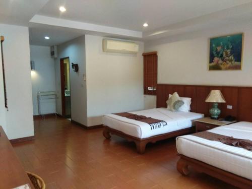 een hotelkamer met 2 bedden en een tafel bij Sailom Resort Bangsaphan in Bang Saphan
