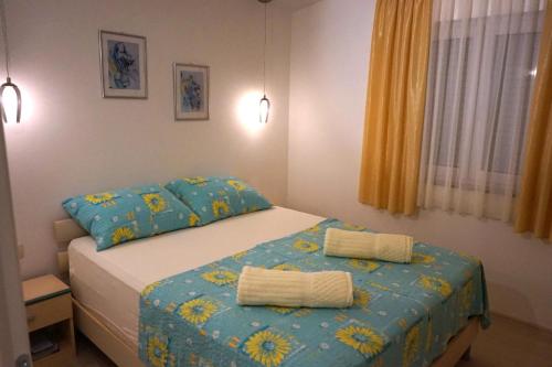 ein Schlafzimmer mit einem Bett und zwei Kissen darauf in der Unterkunft Apartments with a parking space Omisalj, Krk - 12793 in Omišalj