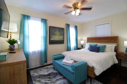 a bedroom with a bed and a blue chair at Beachy Bungalow for Family Fun! Walk to beach! in Pensacola