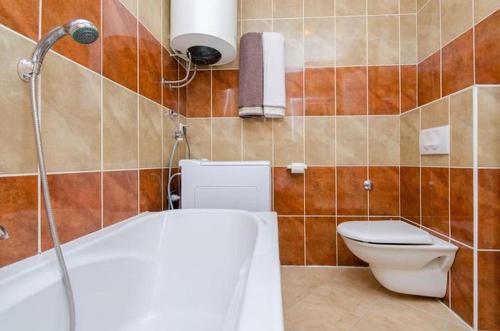 uma casa de banho com uma banheira, um WC e um chuveiro em Apartments with a parking space Novi Vinodolski - 12790 em Novi Vinodolski