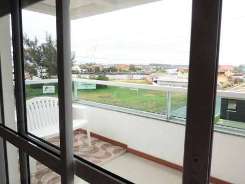a balcony with a bench and a view of a city at Pousada Molhes da Barra in Torres