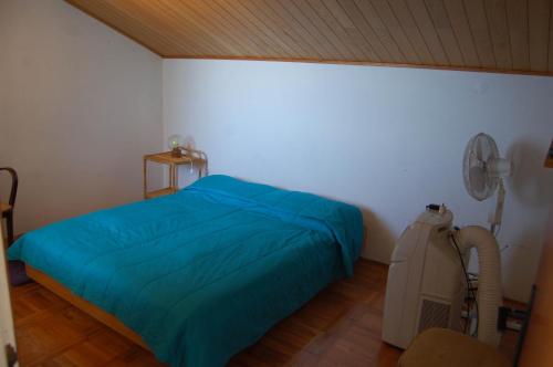 1 dormitorio con 1 cama azul y ventilador en Seaside holiday house Ivan Dolac, Hvar - 12958, en Jelsa