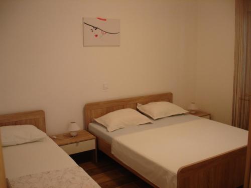 2 aparte bedden in een slaapkamer met een foto aan de muur bij Apartments with a parking space Orebic, Peljesac - 12361 in Orebić