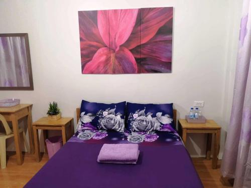 a purple bed in a room with a painting on the wall at CANIBAD SECRET PARADISE RESORT in Aumbay