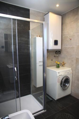 a bathroom with a shower and a washing machine at Seaside holiday house Postira, Brac - 13001 in Postira