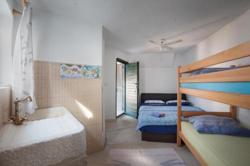 a bedroom with a bunk bed and a bed and a tub at Secluded fisherman's cottage Cove Tvrdni Dolac, Hvar - 13018 in Gdinj