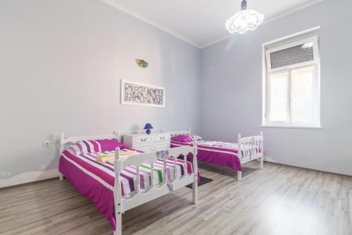 Cette chambre blanche dispose de deux lits et d'une fenêtre. dans l'établissement Apartments with WiFi Pula - 13031, à Pula