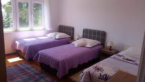 a bedroom with two beds and two windows at Apartments by the sea Hvar - 13041 in Hvar
