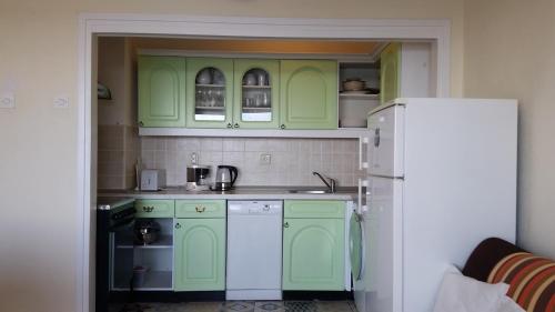 a kitchen with green cabinets and a white refrigerator at Apartments by the sea Hvar - 13041 in Hvar
