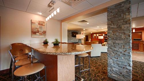 a lobby with a bar with stools and a stone pillar at Comfort Inn & Suites Copley Akron in Copley