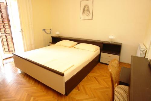 a bedroom with a bed and a table and a chair at Double Room Pag 13060a in Pag