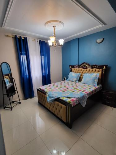 a bedroom with a bed with blue walls and blue curtains at Lux Résidence in Yaoundé