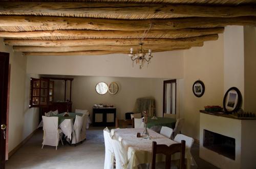 a dining room with tables and chairs and wooden ceilings at El Zorro Gris in Tinogasta
