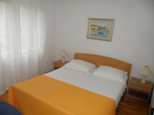 a bedroom with a bed and two night stands with two lamps at Seaside holiday house Drace, Peljesac - 13117 in Janjina