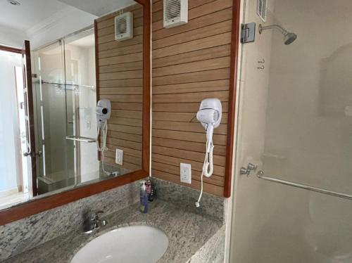a bathroom with a sink and a mirror and a shower at capitan suites sea view in Cancún