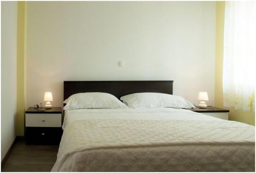 une chambre avec un grand lit avec deux lampes sur des tables dans l'établissement Apartments by the sea Kali, Ugljan - 13147, à Kali