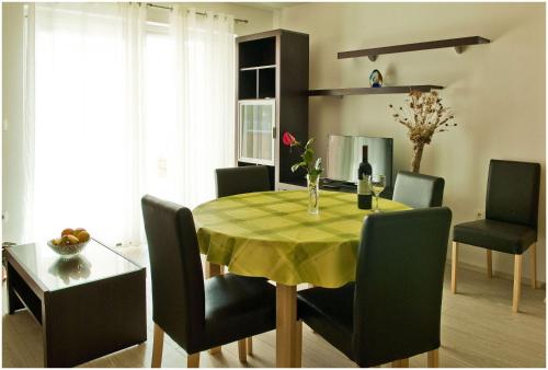 une table de salle à manger avec une nappe jaune et des chaises dans l'établissement Apartments by the sea Kali, Ugljan - 13147, à Kali