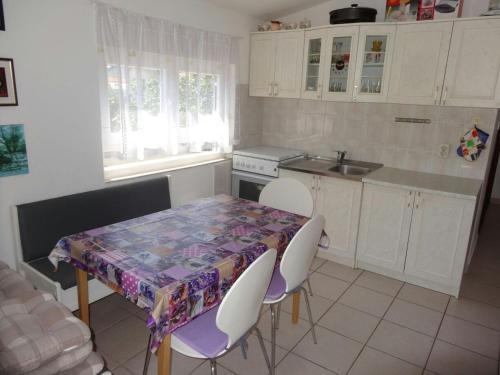 kuchnia ze stołem i białymi szafkami oraz stołem i krzesłami w obiekcie Apartments with a parking space Sabunike, Zadar - 13150 w Nin