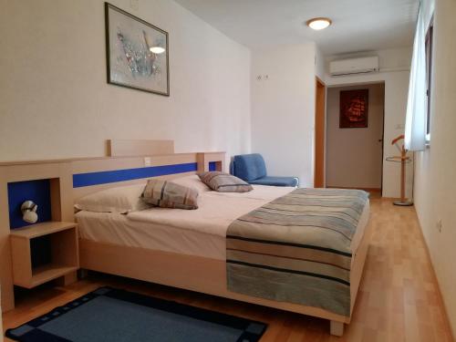 - une chambre avec un grand lit et une chaise bleue dans l'établissement Apartments with a parking space Rabac, Labin - 13151, à Rabac
