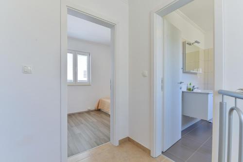 een badkamer met een spiegel en een wastafel bij Apartments by the sea Nin, Zadar - 13172 in Nin