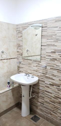 サルタにあるDUO HOMEの白い洗面台と鏡のあるバスルーム