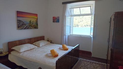 ein Schlafzimmer mit einem Bett mit gelben Kissen darauf in der Unterkunft Apartments by the sea Broce, Peljesac - 13182 in Ston