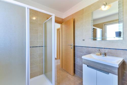 uma casa de banho com um lavatório e um chuveiro em Apartment Nin 13172d em Nin