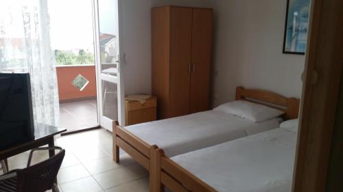a small bedroom with two beds and a tv at Apartments with parking space Novalja, Pag - 13200 in Novalja