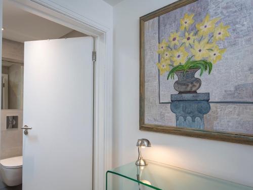 a bathroom with a glass table with a vase of flowers at The Bothy in Slapton