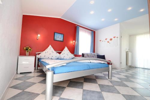 ein Schlafzimmer mit einem Bett mit einer roten Wand in der Unterkunft Apartments with parking space Porec - 13141 in Poreč